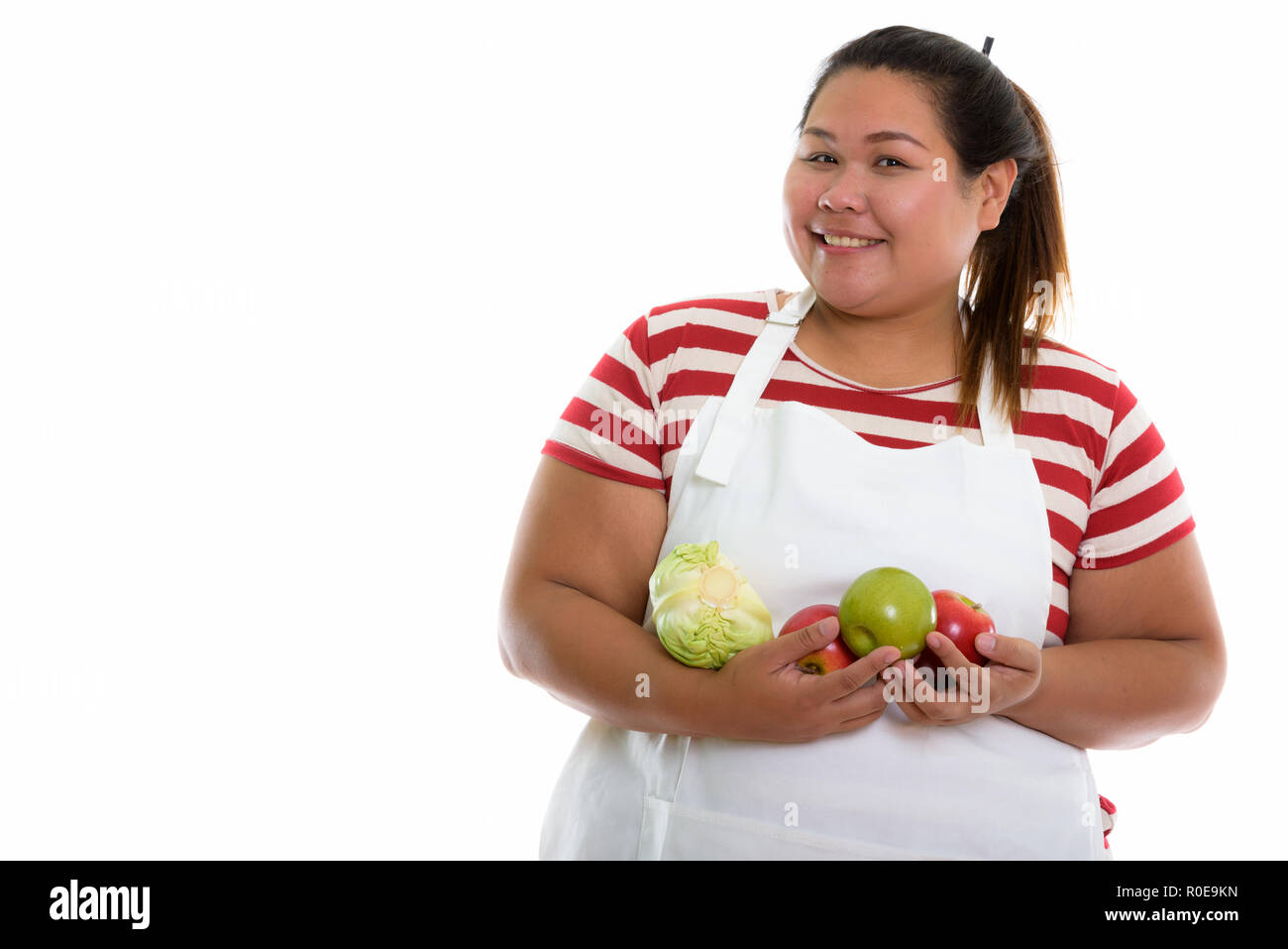 Studio shot of young woman smiling Asian fat heureux tout en maintenant Banque D'Images