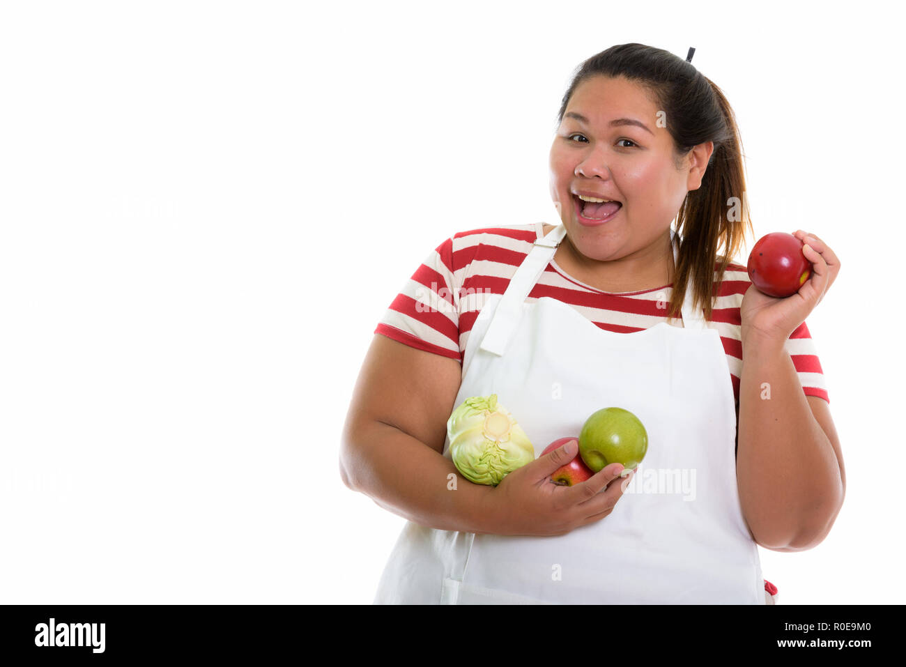 Studio shot of young woman smiling Asian fat heureux tout en maintenant Banque D'Images