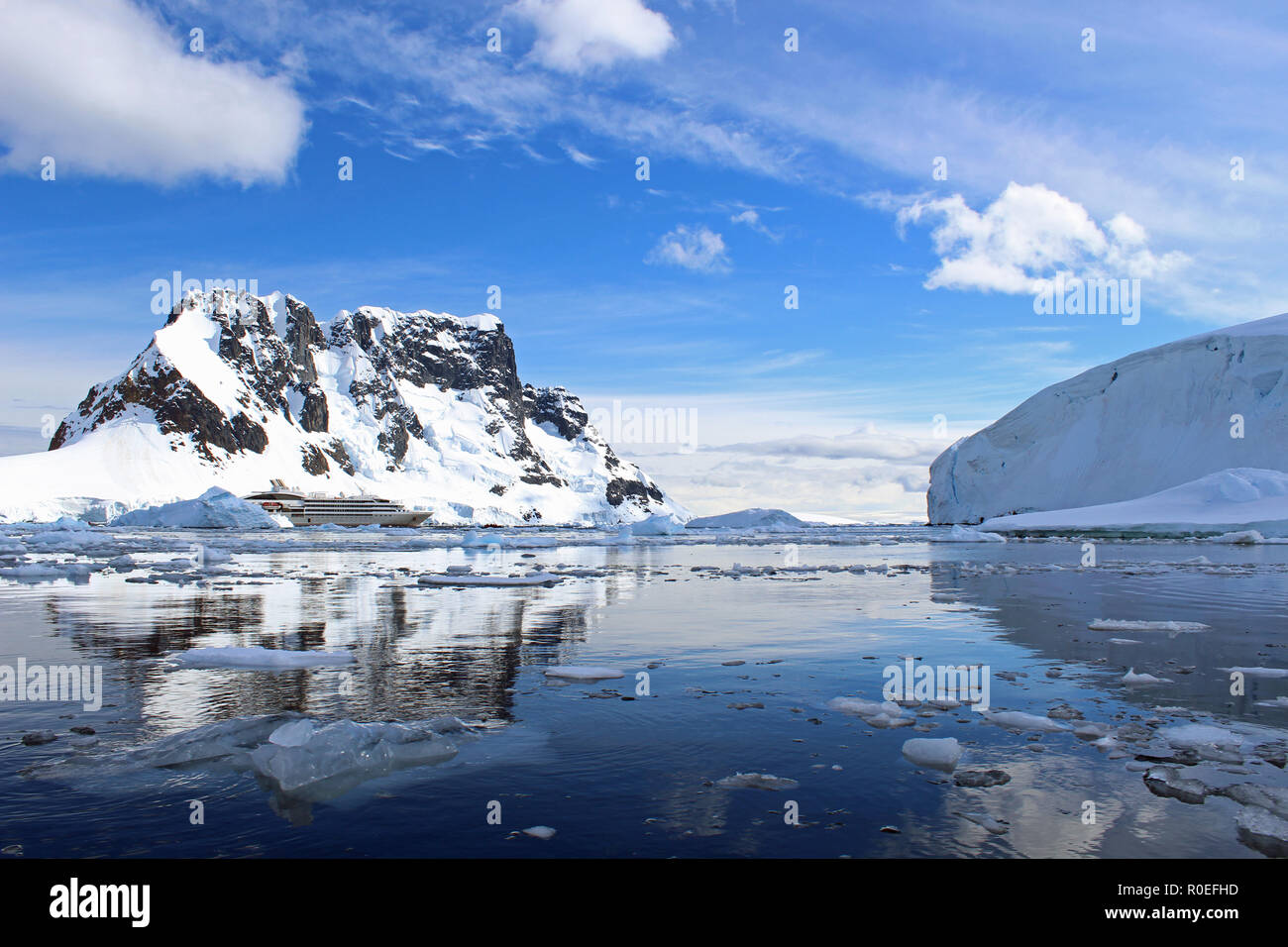 Un navire de croisière expédition en Antarctique à l'ancre au milieu de l'eau glacée scintillants, reflet de Paradise Bay dans la péninsule antarctique le long d'une journée d'été Banque D'Images