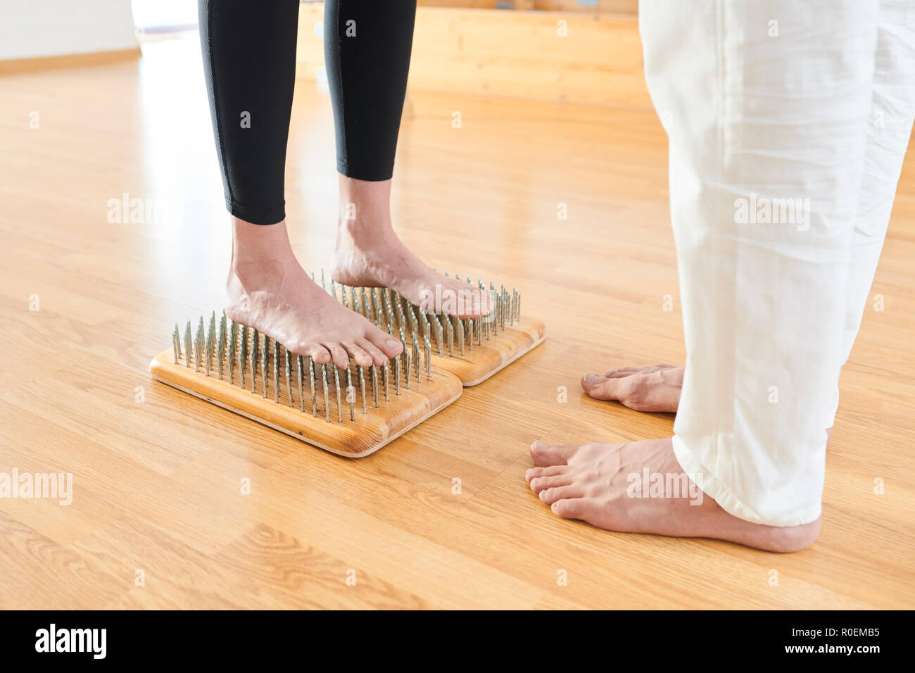 Brave femme debout sur lit de clous à la pratique du yoga Banque D'Images