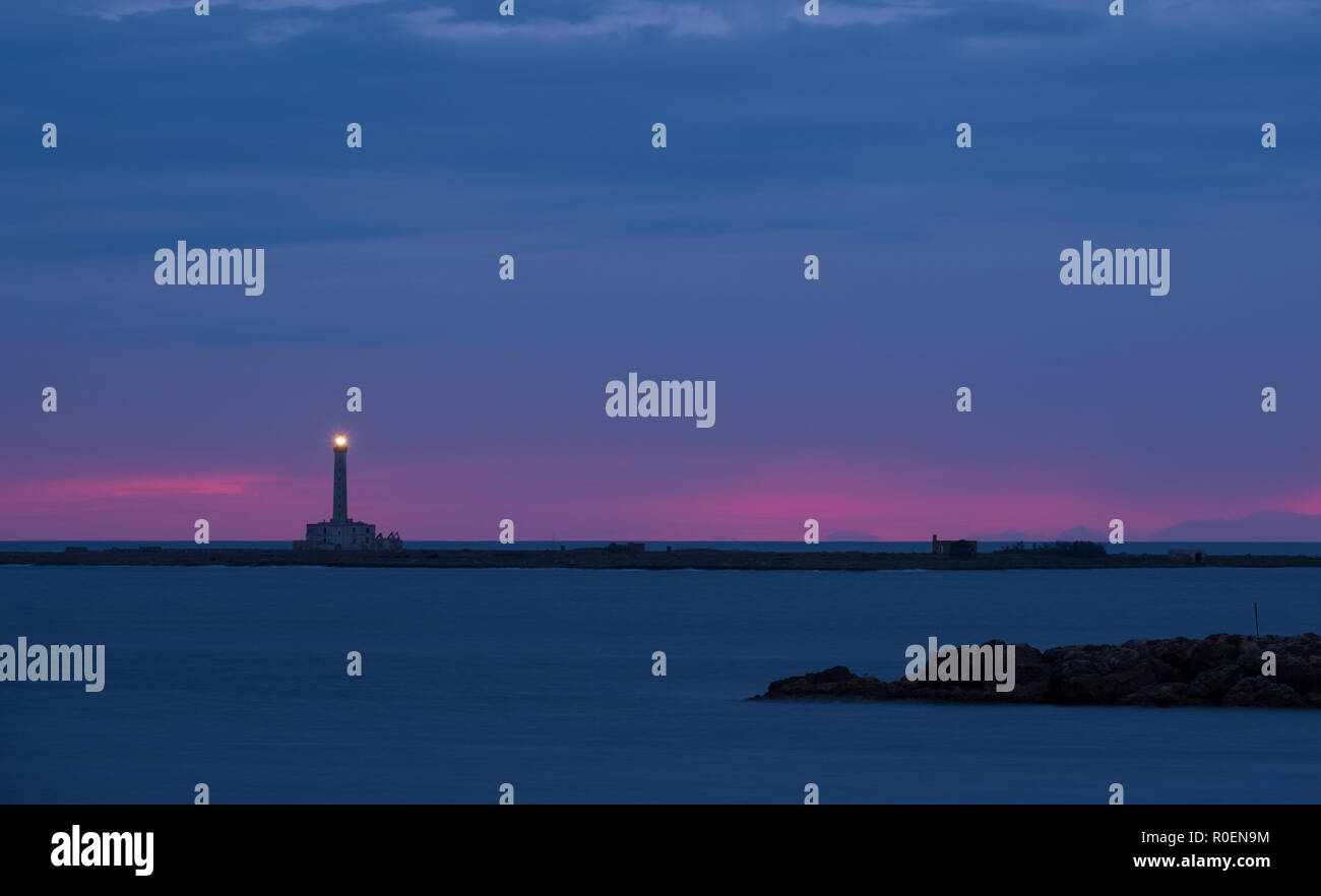 Leuchtturm photographié contre le coucher du soleil avec pink sky, à Gallipoli, Péninsule du Salento, les Pouilles, Italie du Sud. Banque D'Images