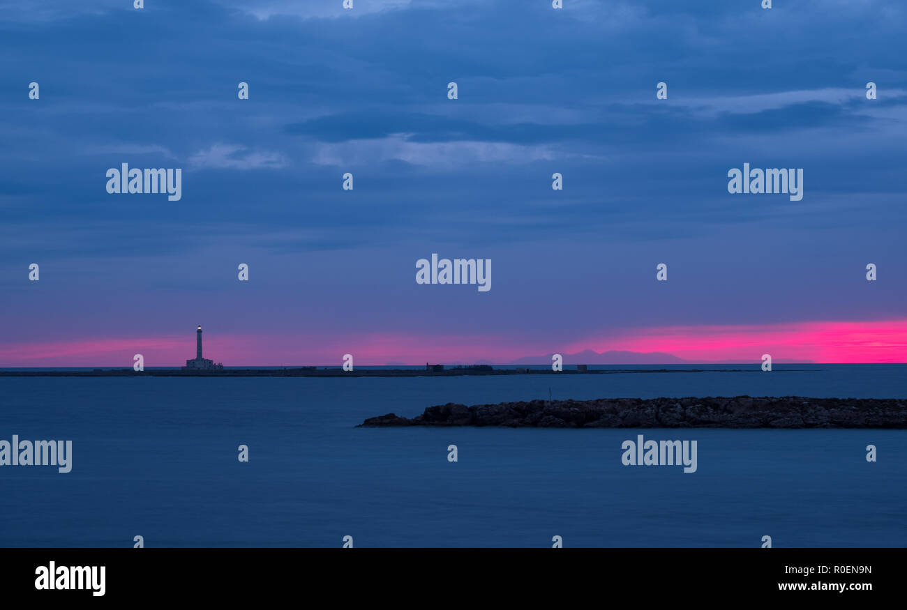 Leuchtturm photographié contre le coucher du soleil avec pink sky, à Gallipoli, Péninsule du Salento, les Pouilles, Italie du Sud. Banque D'Images