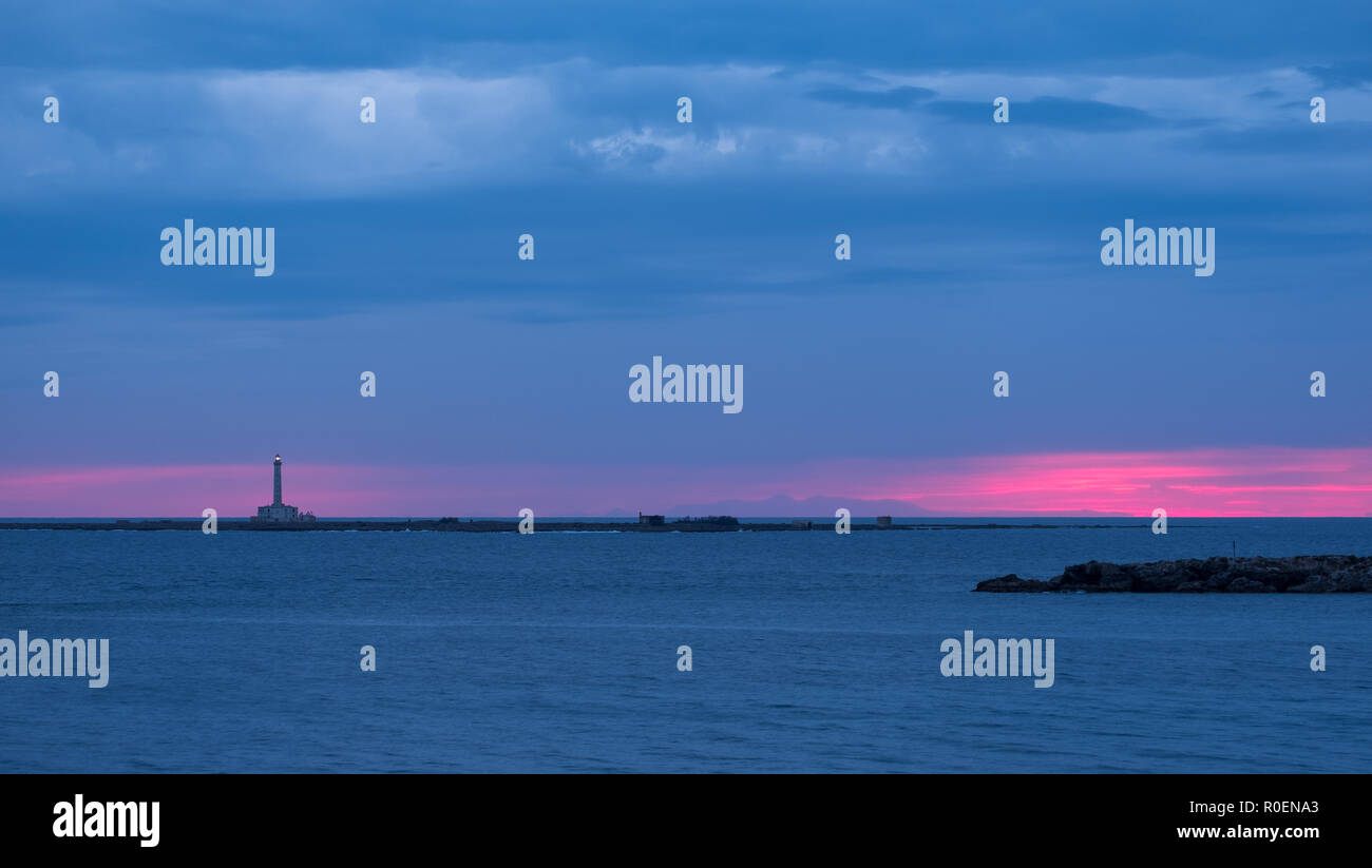 Leuchtturm photographié contre le coucher du soleil avec pink sky, à Gallipoli, Péninsule du Salento, les Pouilles, Italie du Sud. Banque D'Images