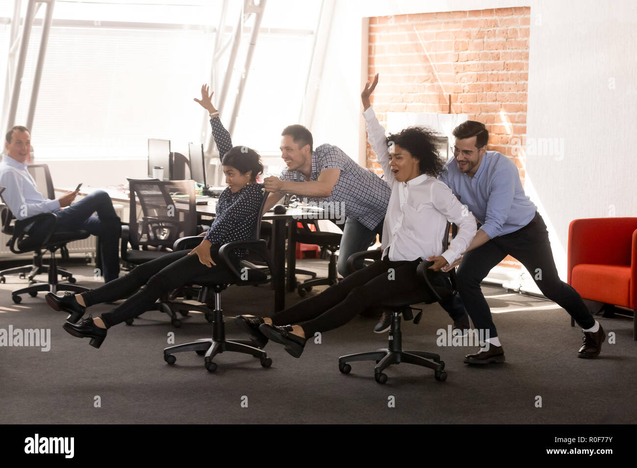 Les employés de bureau divers excité insouciante having fun riding oh cha Banque D'Images