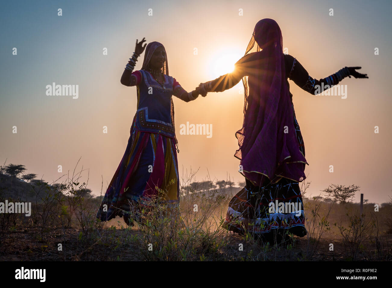 Deux silhouettes de femmes gitanes dancing au coucher du soleil, Pushkar Camel Fair, Pushkar, Rajasthan, India Banque D'Images