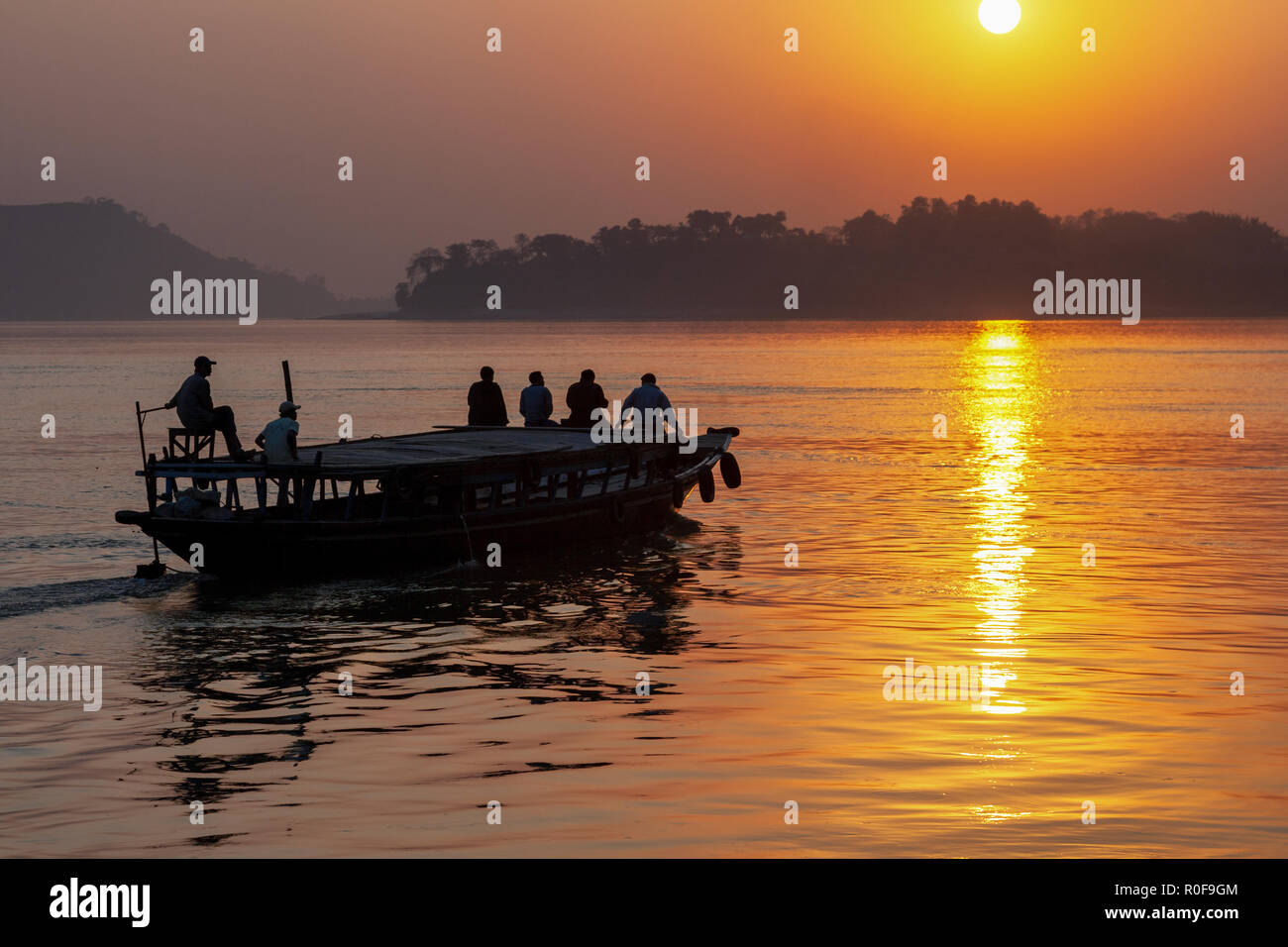 Un petit bateau sur le Brahmapoutre au coucher du soleil, de l'Assam, Inde Banque D'Images