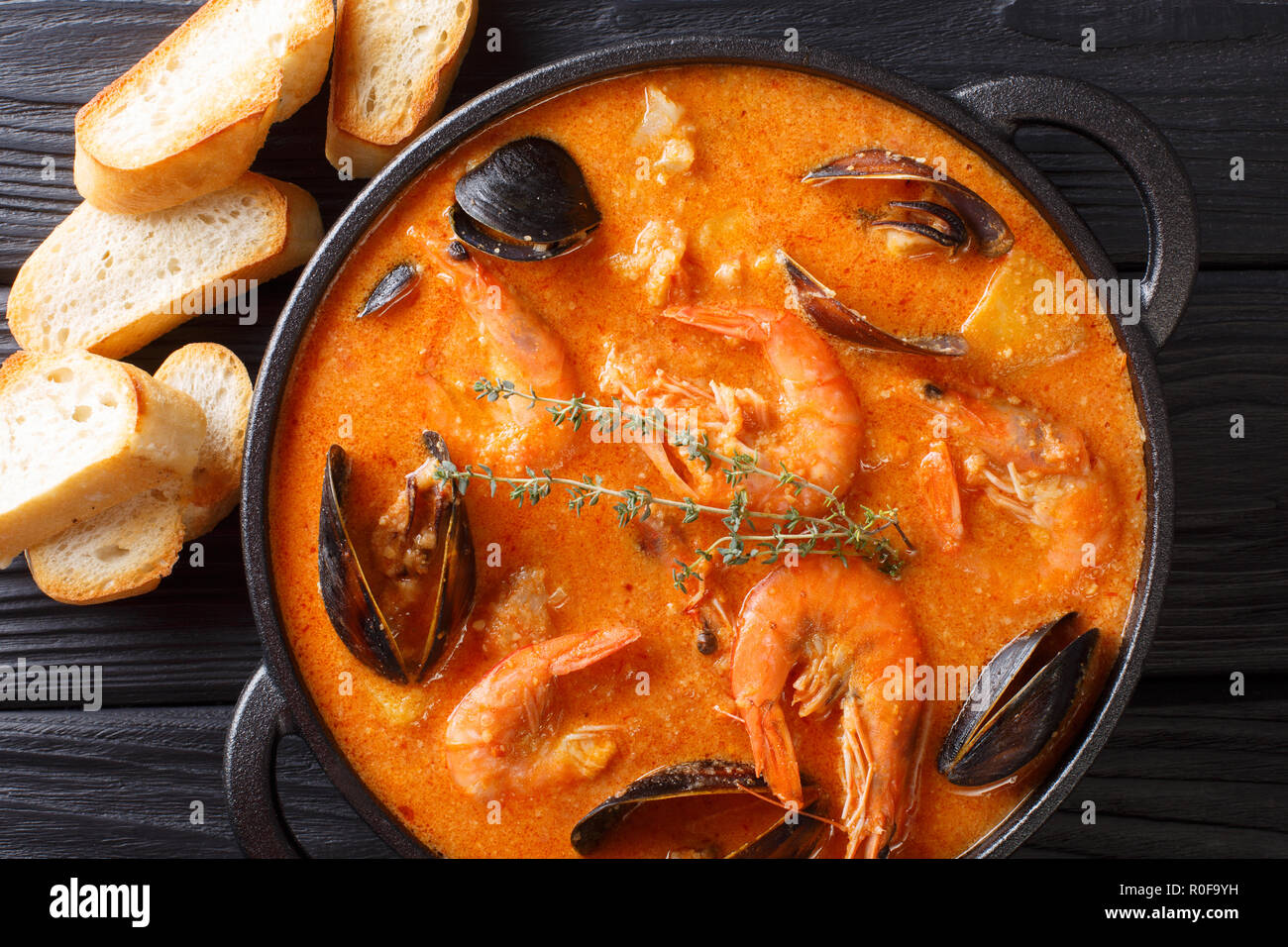 Authentique catalane Suquet de Peix soupe épicée avec pommes de terre, crevettes, moules, les herbes et le poisson avec picad close-up dans une casserole sur la table supérieure horizontale. Banque D'Images