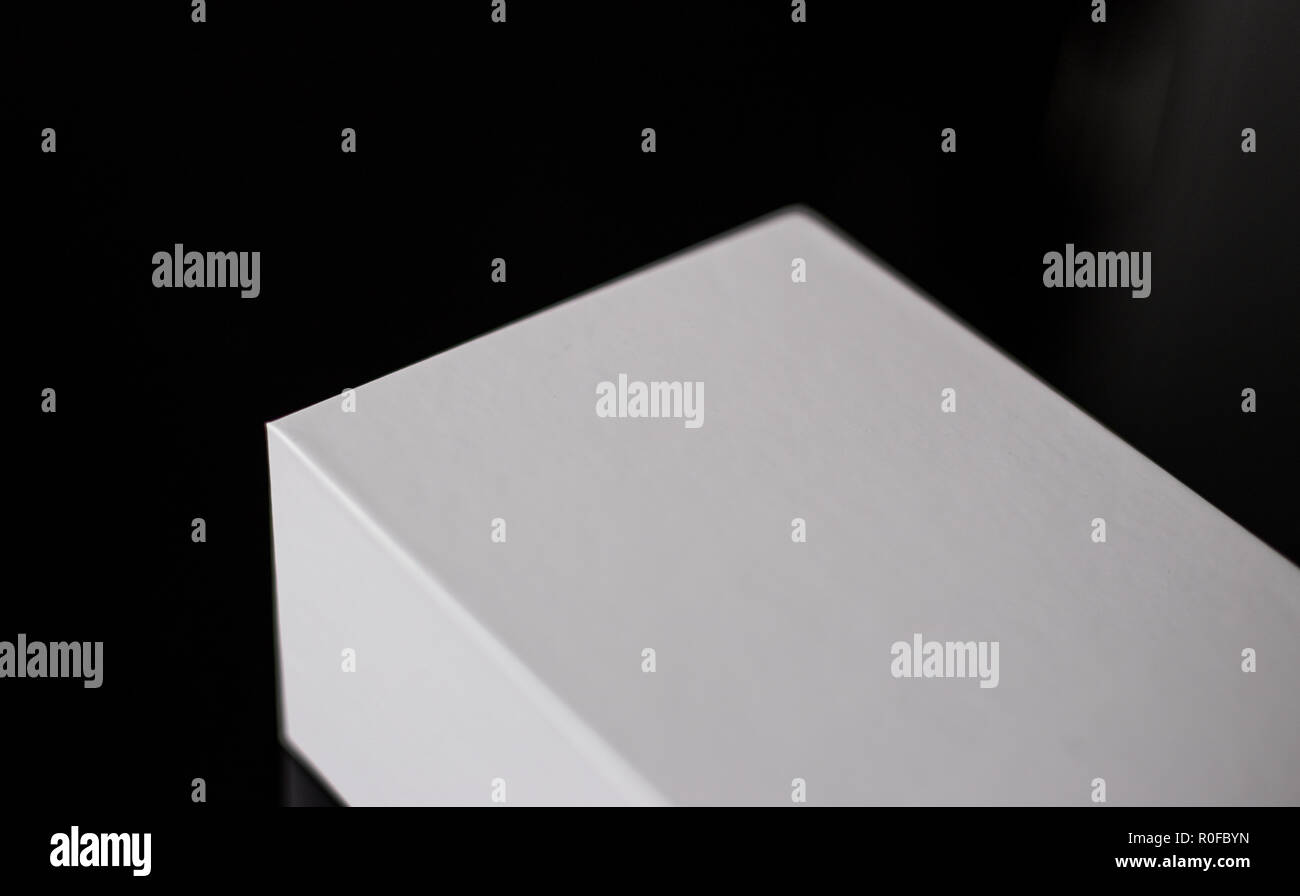L'emballage vide isolé case blanche en papier carton sur une surface noire brillante - l'espace pour copier Banque D'Images