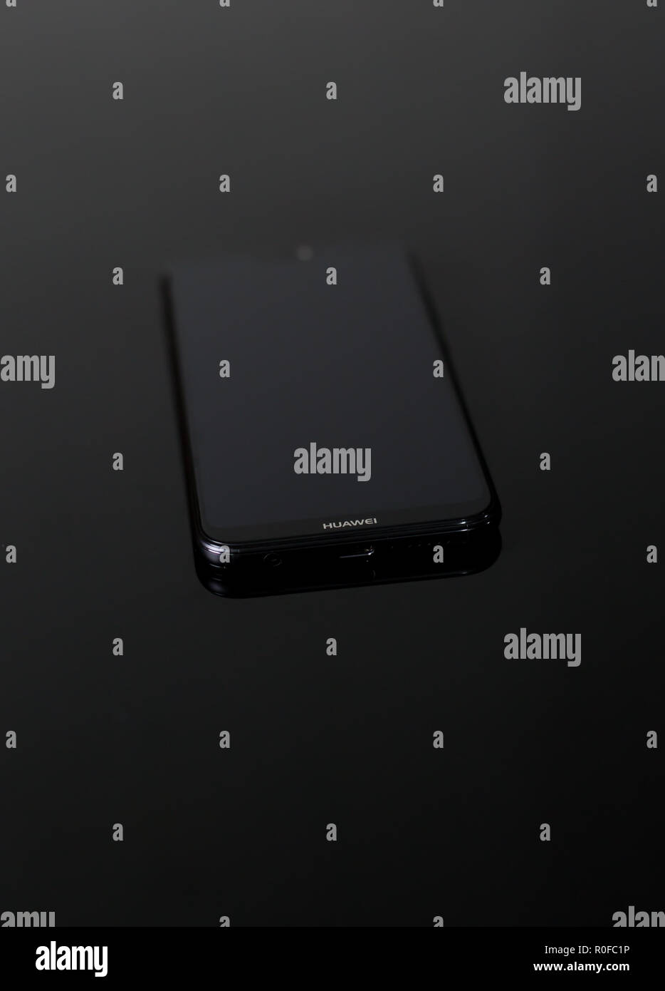 Tout nouveau P20 Lite mobile cell phone faites par la marque chinoise Huawei avec courbe lisse bords sur une surface noire réfléchissante Banque D'Images