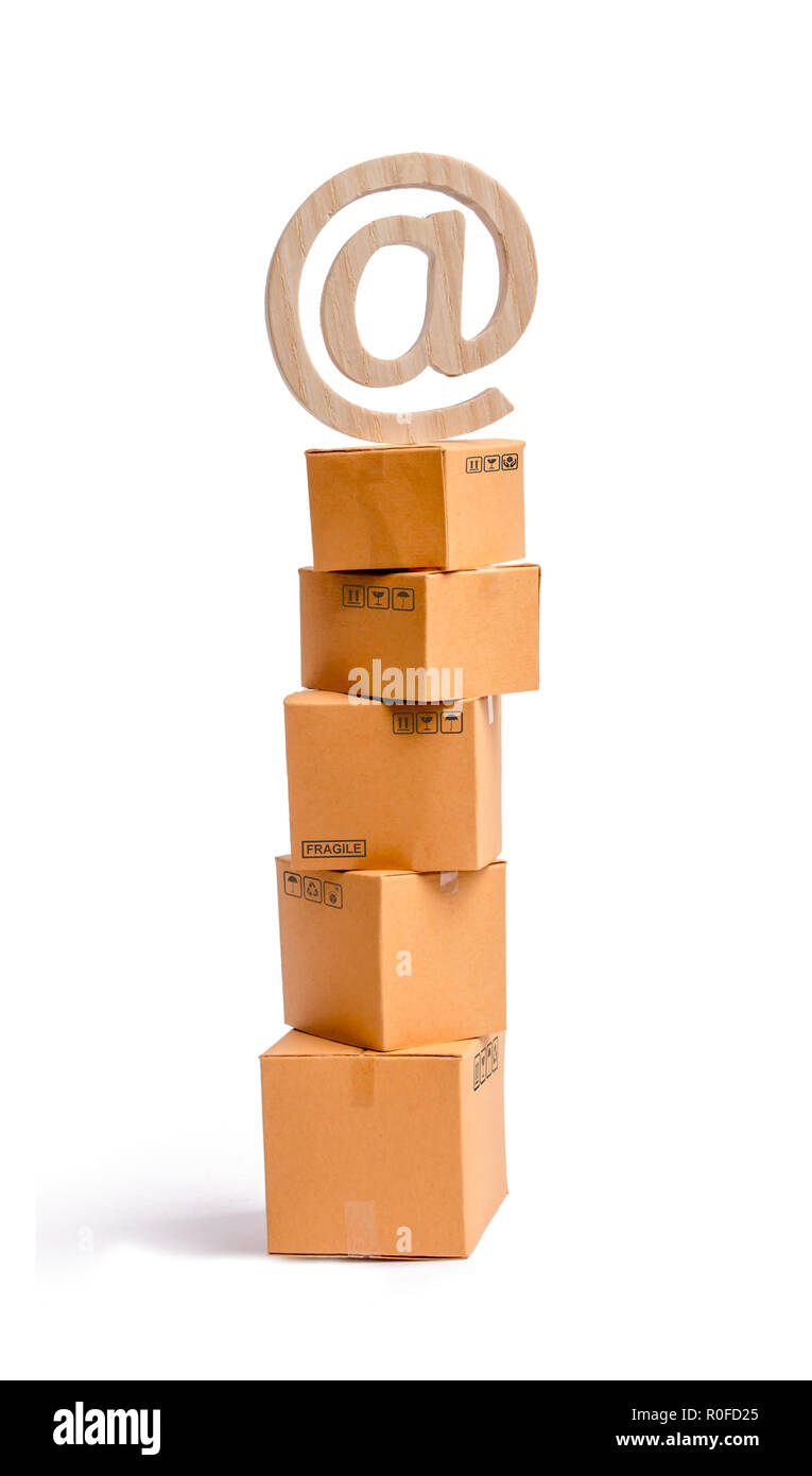 Une tour de boîtes de carton et un symbole e-mail sur le dessus. Le concept de vente en ligne, le shopping et les achats en ligne. Réalisation de produits et services e Banque D'Images