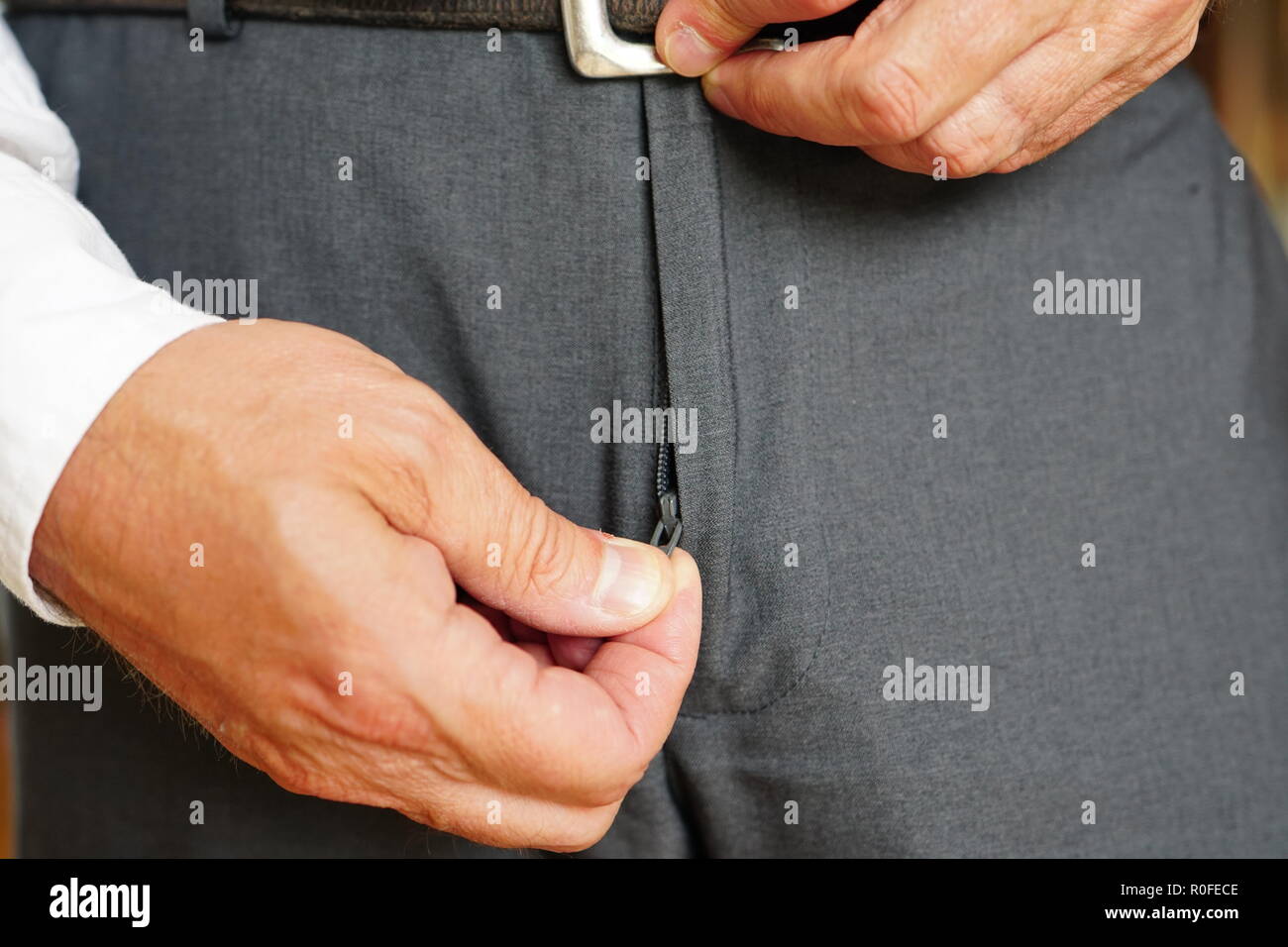 Un homme est la compression ou décompression de son pantalon gris. Banque D'Images