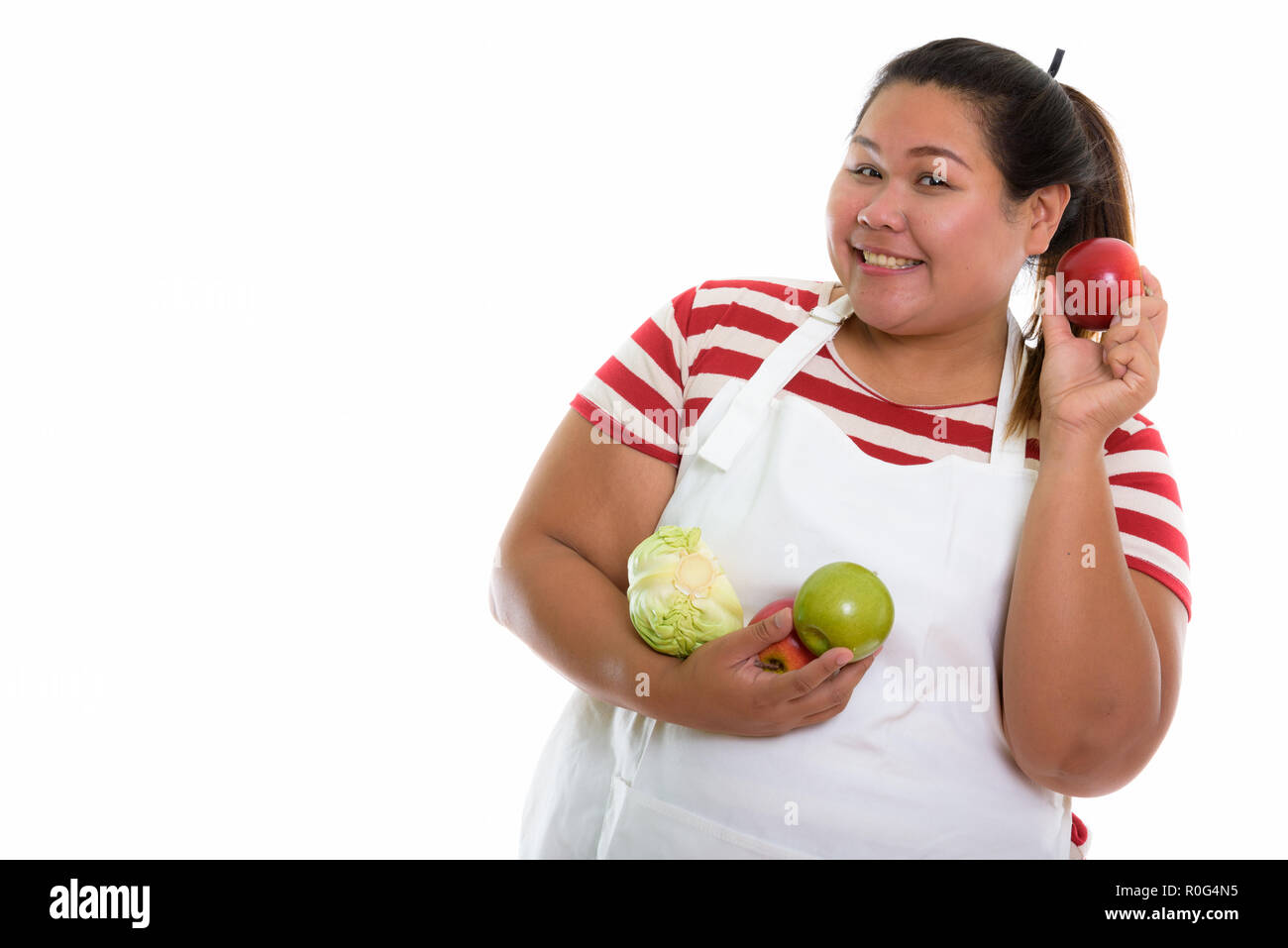 Studio shot of young woman smiling Asian fat heureux tout en maintenant Banque D'Images