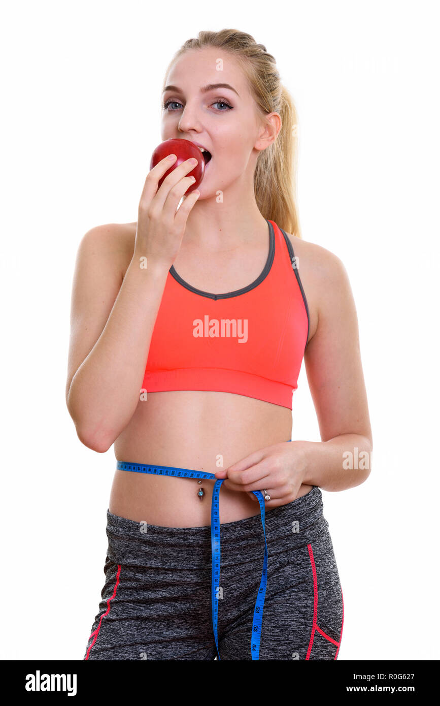 Studio shot of young beautiful teenage girl eating red apple et Banque D'Images