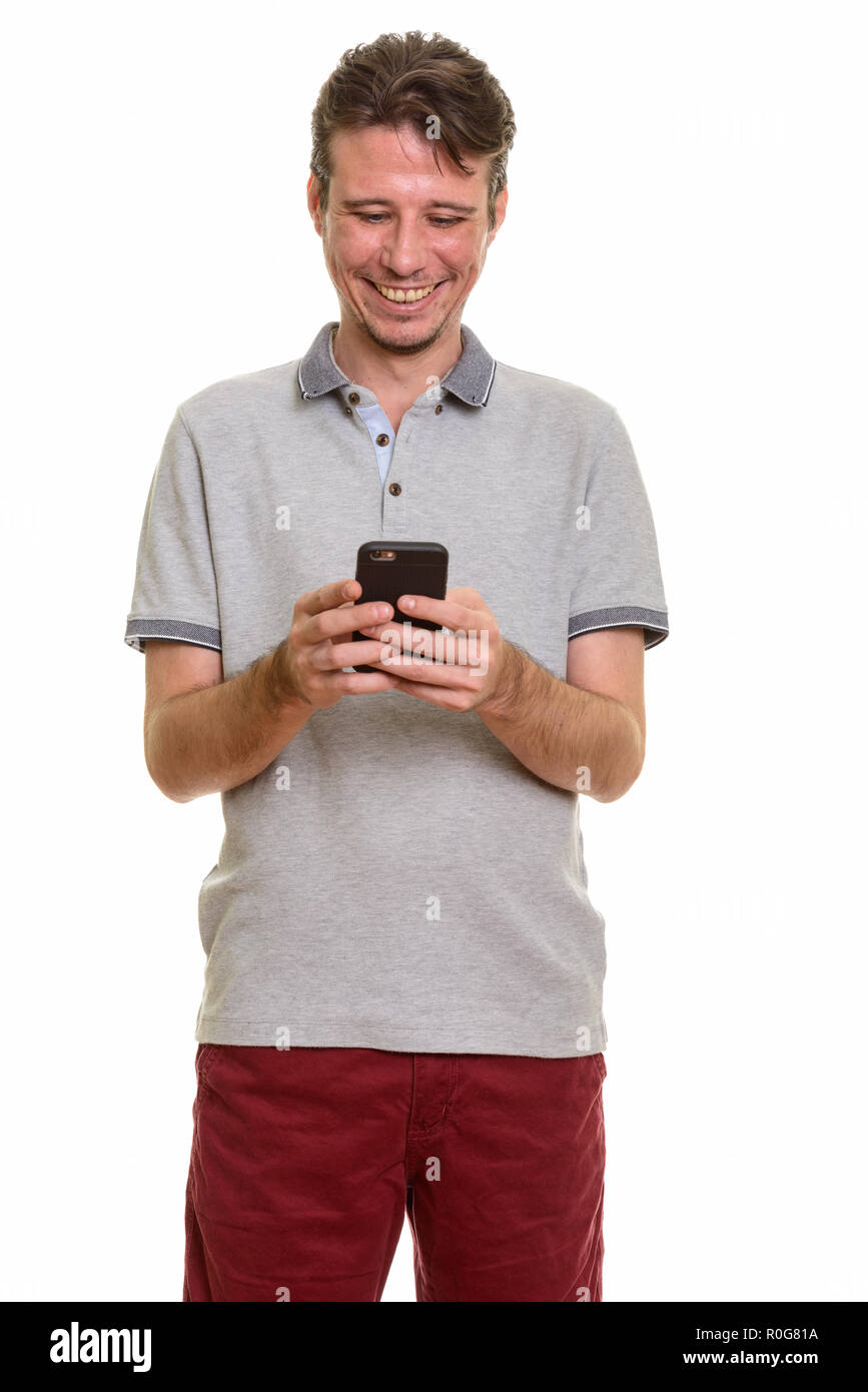 Happy Caucasian man smiling et using mobile phone Banque D'Images