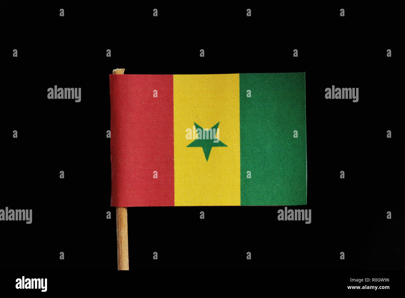 Un drapeau original et officiel du Sénégal sur les cure-dents sur fond noir. Une verticale de 3 couleurs vert jaune et rouge avec étoile verte au centre. Banque D'Images