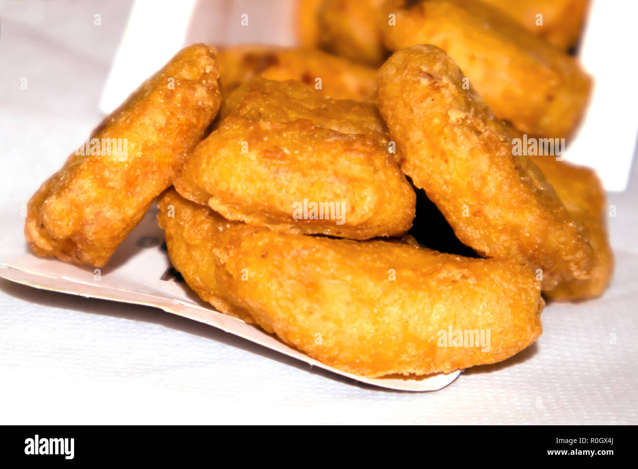 Pile de nuggets de poulet frit croustillant de tomber d'une boîte de papier Banque D'Images