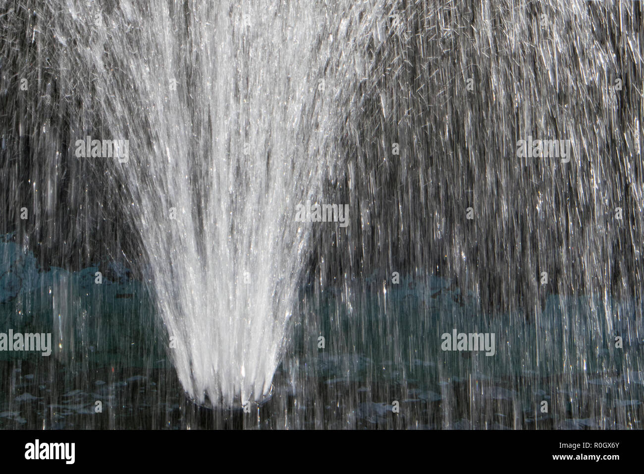 Petite fontaine en forme de ventilateur au milieu d'une petite piscine dans le parc Banque D'Images