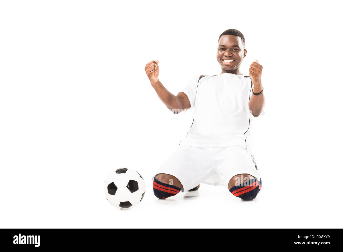 Happy young african american soccer player triomphant et agitant poings isolated on white Banque D'Images