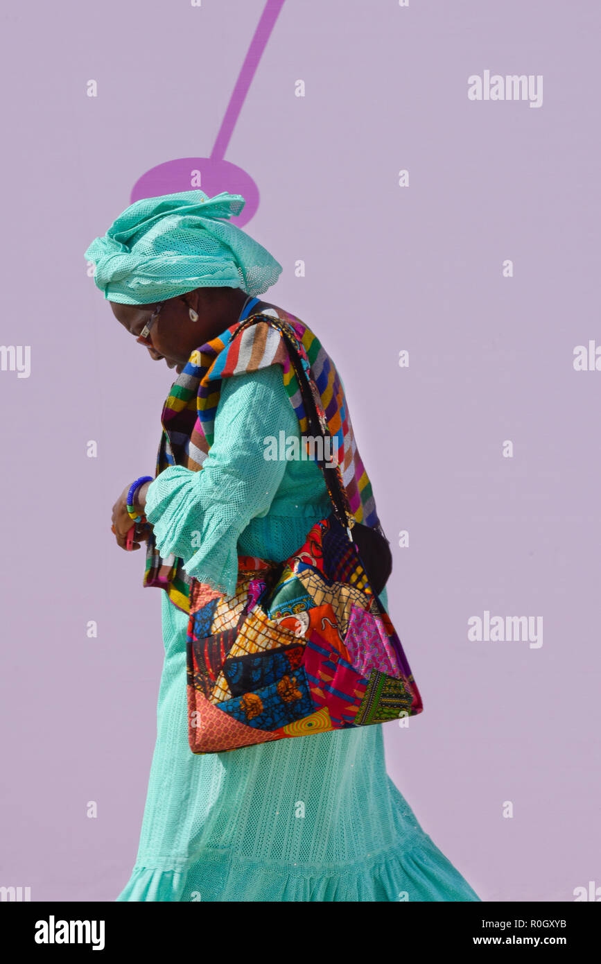 Femme africaine en vêtements traditionnels colorés marcher avec sa tête vers le bas Banque D'Images