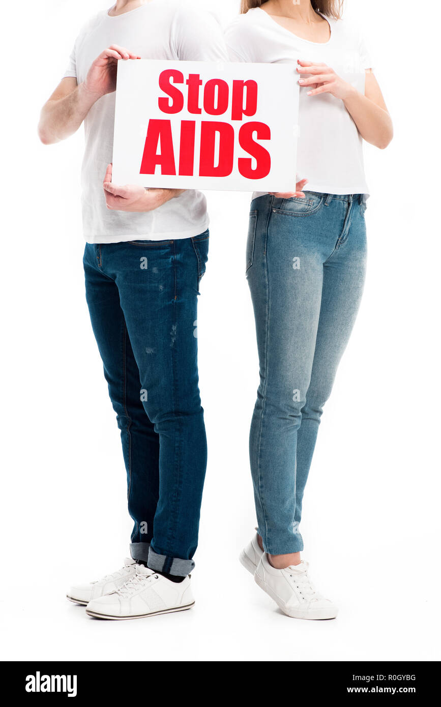 Portrait de couple hétérosexuel dans les tenues en tenant la carte avec texte Stop sida isolated on white Banque D'Images