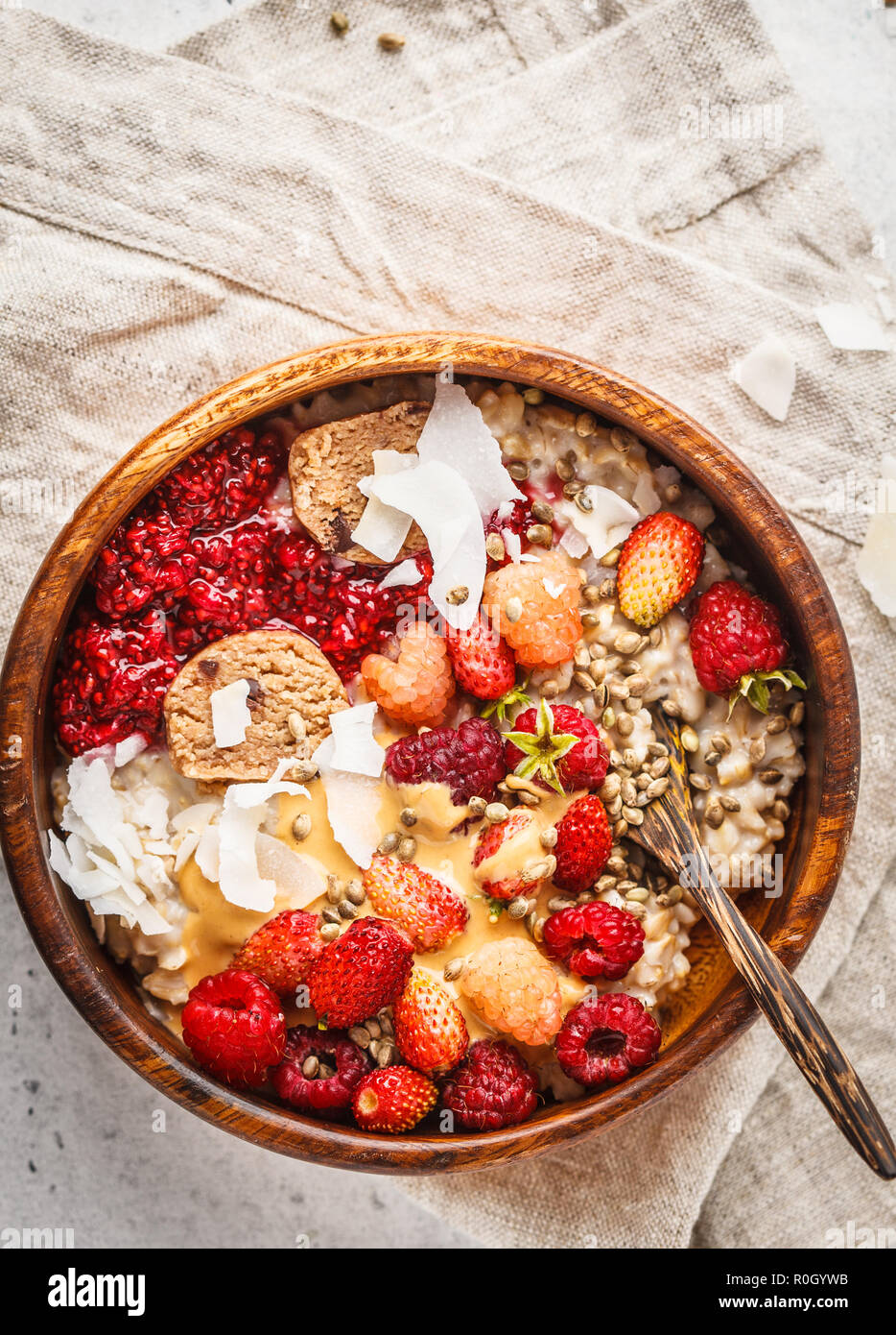 Vegan Trendy bol de gruau d'avoine aux fruits rouges, végétalien premières balles et le beurre d'arachide dans un bol en bois, vue du dessus. Banque D'Images