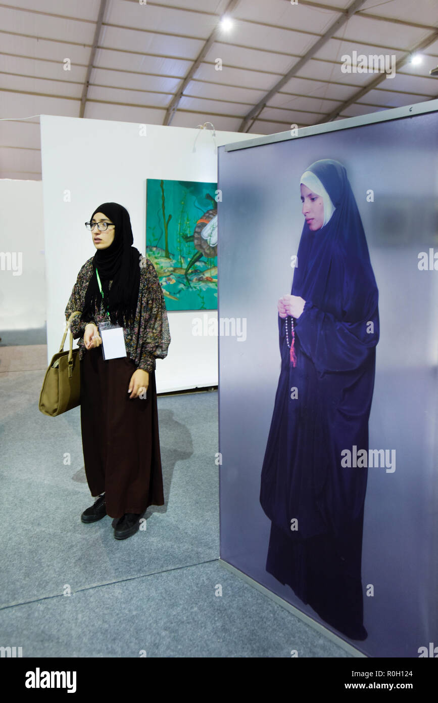 Femme originaire de l'Afrique du nord le port de vêtements traditionnels et jihab visiter une exposition d'art contemporain dans l'Afrique du nord de Marrakech Banque D'Images