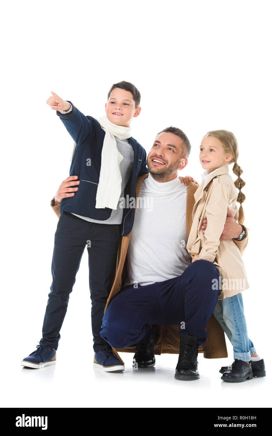 Père élégant serrant les enfants en tenue d'automne, garçon montrant quelque chose d'isolé sur fond blanc Banque D'Images