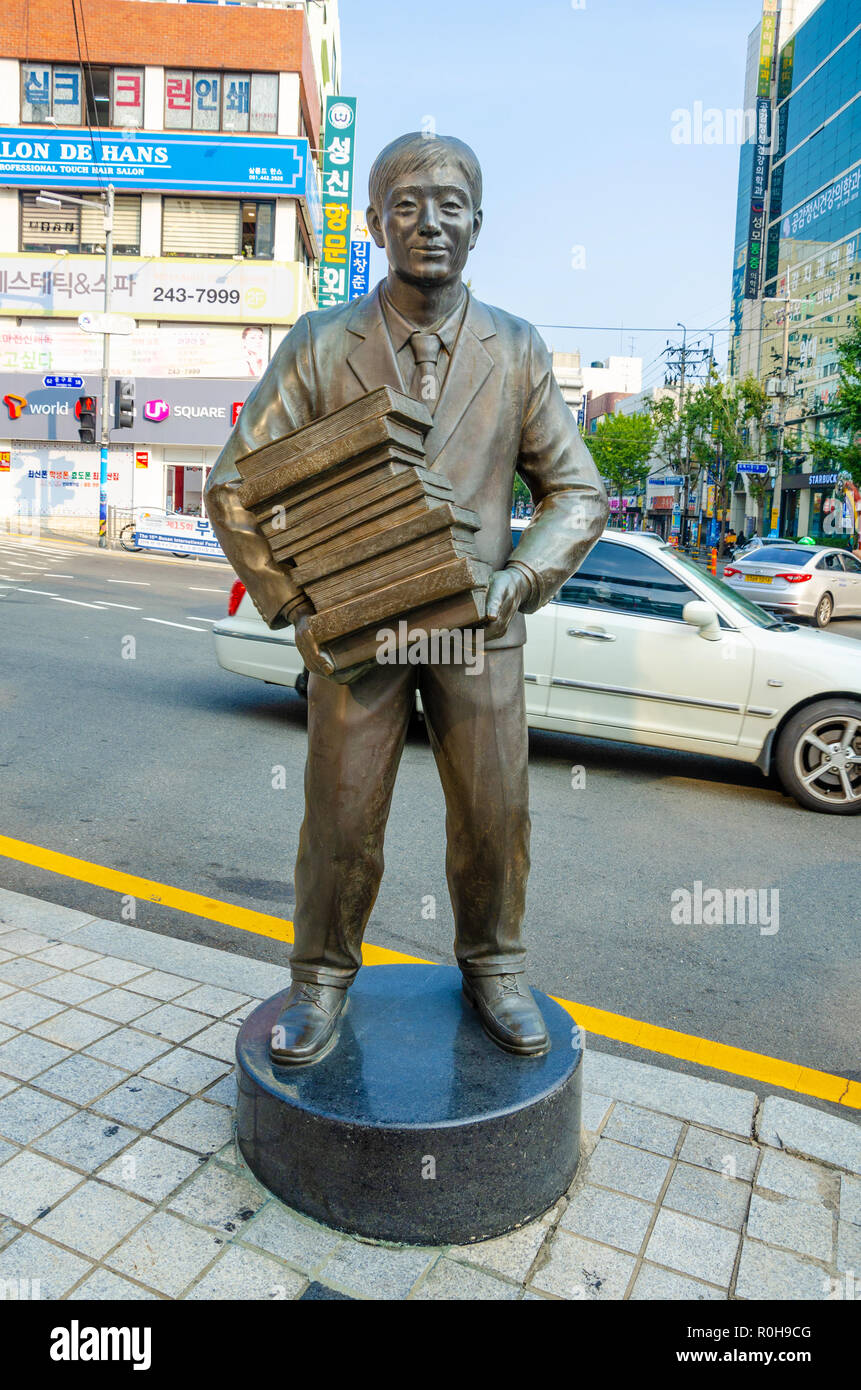 Sculpture en bronze représentant la figure d'un homme portant une pile de livres est sur le coin de rue près de Bosu Livre Dong Alley à Busan, en Corée du Sud. Banque D'Images