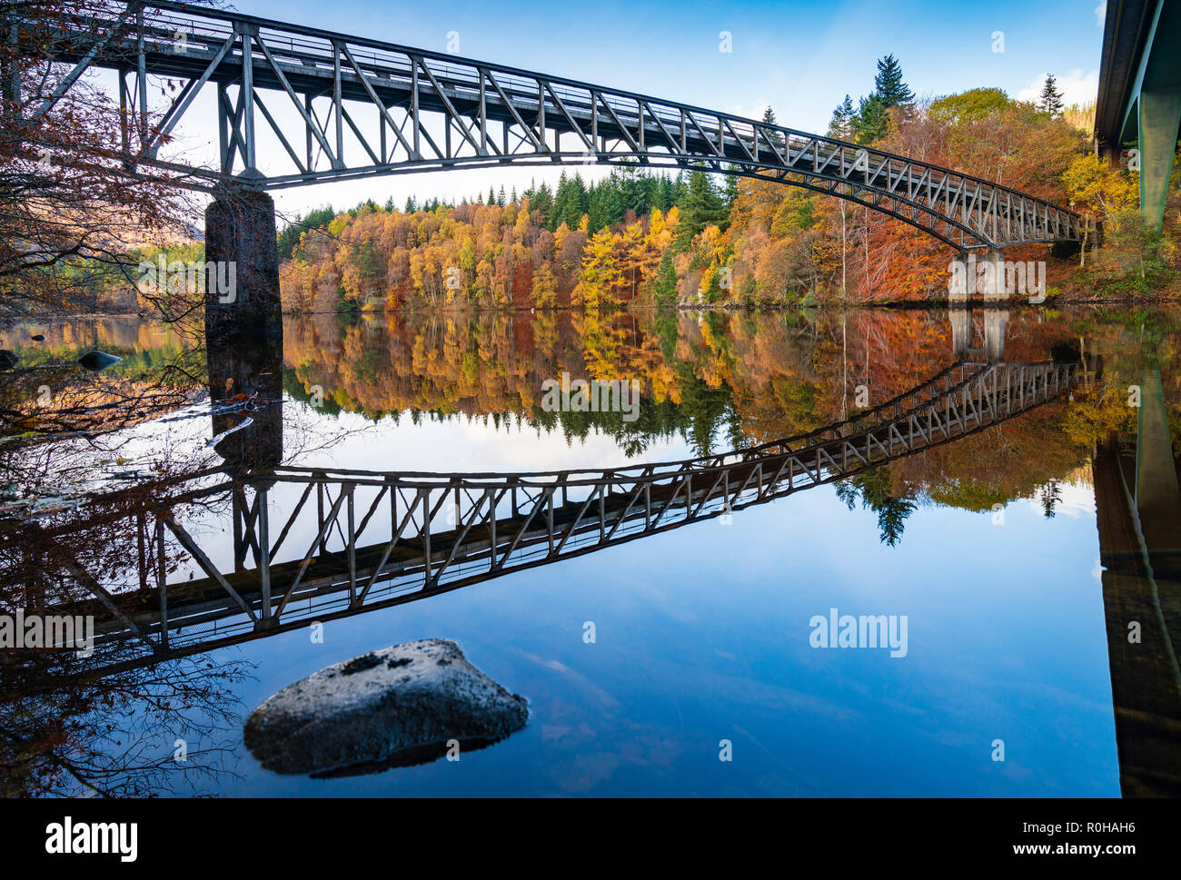 La fin de l'automne, les couleurs des arbres spectaculaires et le pont se reflète dans les eaux du Loch Faskally à Pitlochry, Perthshire, Écosse, Royaume-Uni. Banque D'Images