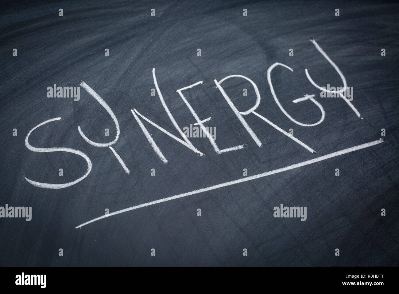 Synergie mot dans l'écriture à la craie blanche sur un tableau noir Banque D'Images