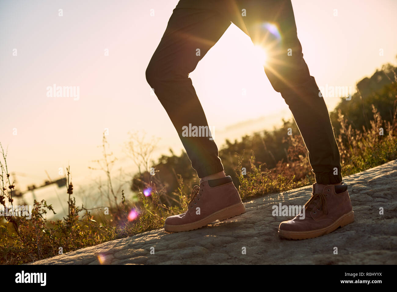 Les jambes de jeunes ce que blogger touristique répond aux coucher du soleil. Photo recadrée Banque D'Images