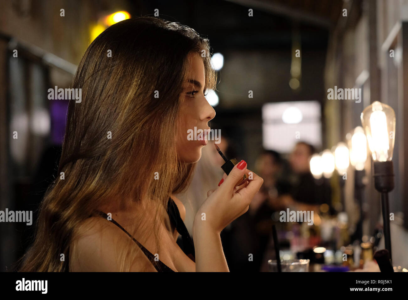 Young woman applying lipstick, Tel Aviv ISRAËL Banque D'Images