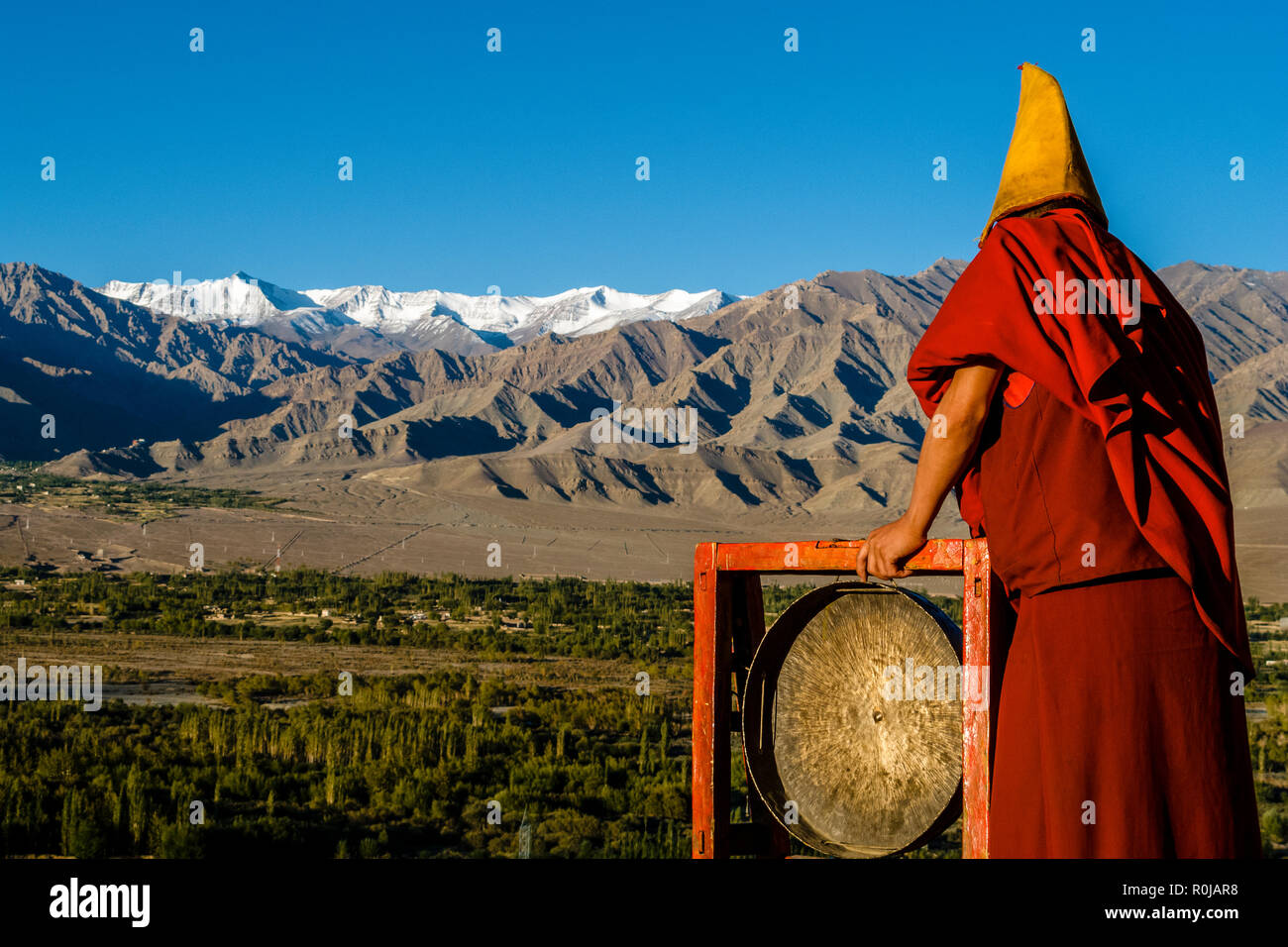 Monks appelant à la prière du matin depuis le toit de Tikse Gompa Banque D'Images