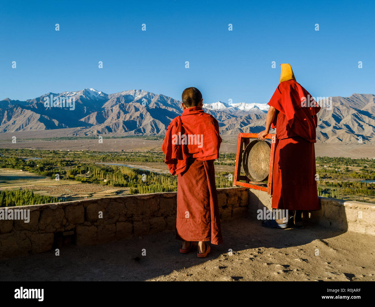 Monks appelant à la prière du matin depuis le toit de Tikse Gompa Banque D'Images