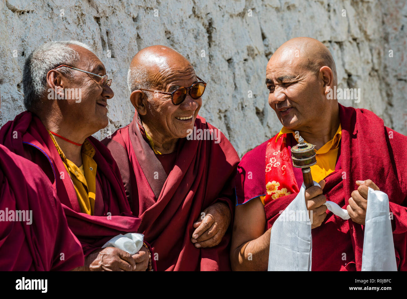 Trois moines de Lamayuru Gompa, le plus ancien et le plus grand monastère existant au Ladakh, portant des vêtements, discutent à la cour. Banque D'Images