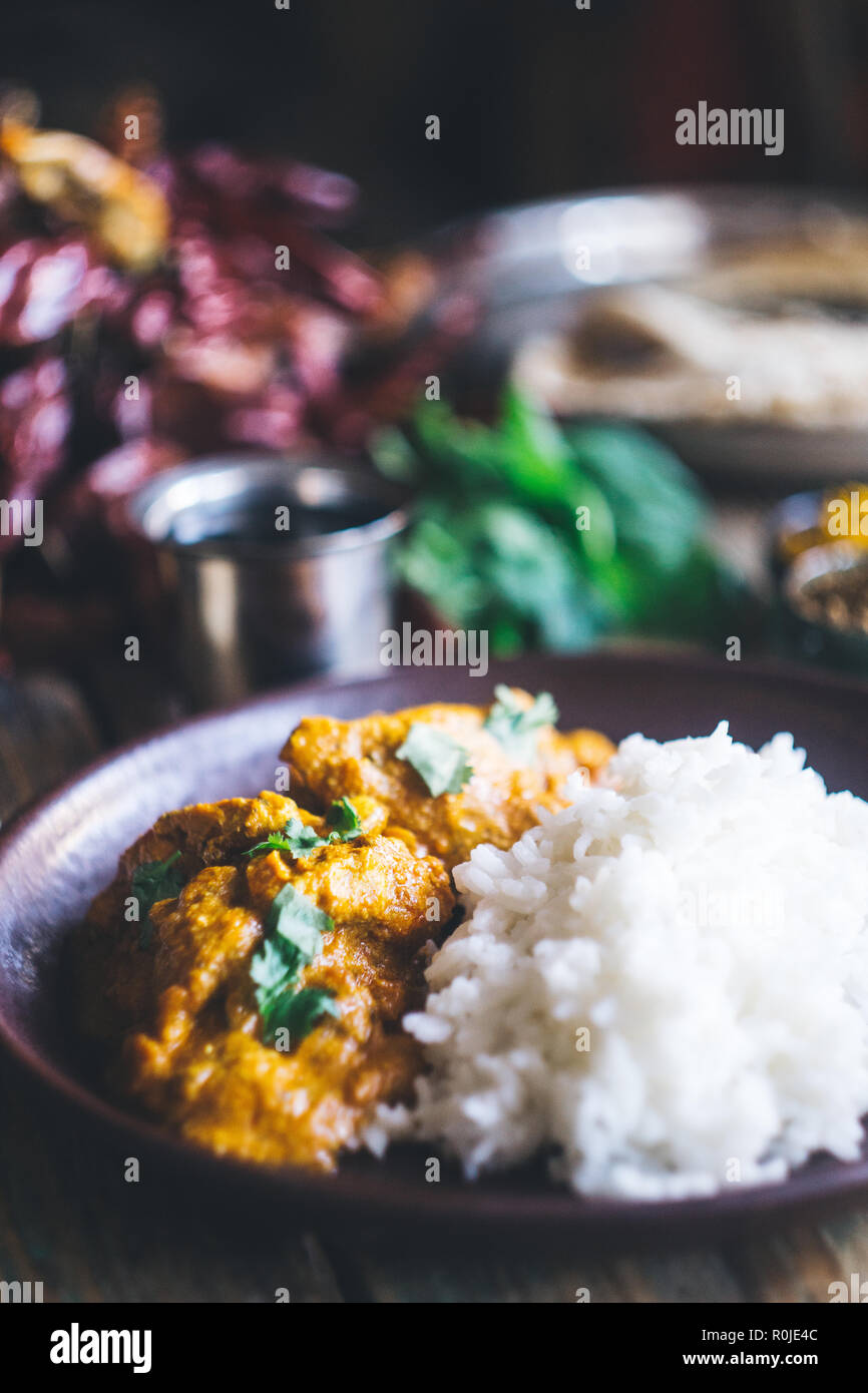 Poulet Tikka Masala (curry indien traditionnel) avec du riz et du pain indien chapati décoré de rouge piquant des piments, coriandre, épices indiennes (tu Banque D'Images