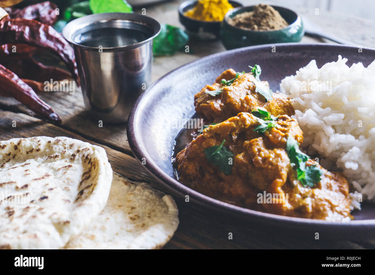 Poulet Tikka Masala (curry indien traditionnel) avec du riz et du pain indien chapati décoré de rouge piquant des piments, coriandre, épices indiennes (tu Banque D'Images
