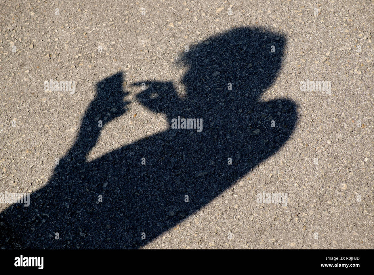 Ombre d'une personne à l'aide d'un smartphone avec une mauvaise posture Banque D'Images