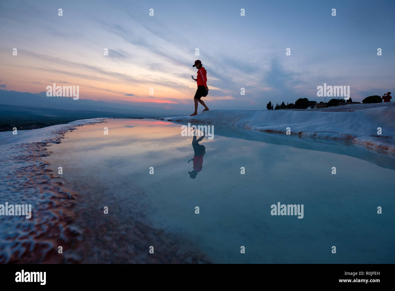 Jeune femme marche sur l'eau minérale en terrasses des château de coton à Pamukkale, Turquie Banque D'Images