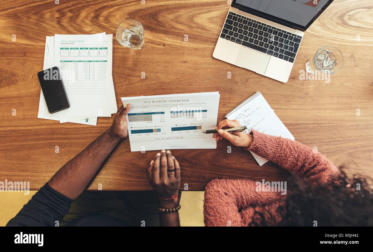 homme d'affaires et femme assis dans le bureau discutant du travail en utilisant des papiers d'affaires. collègues d'affaires assis à la table de travail avec papiers d'affaires et ordinateur portable Banque D'Images