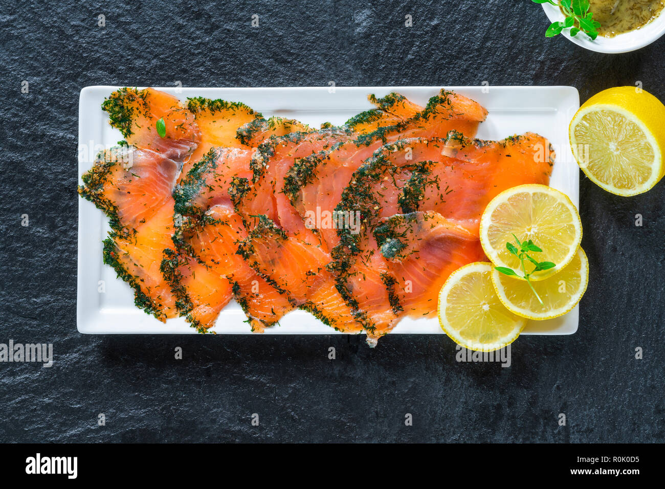 Gravadlax - Nordic plat de fines tranches de saumon cru guérie dans le sel, le sucre et l'aneth et accompagnée par l'aneth et sauce moutarde - Vue de dessus Banque D'Images