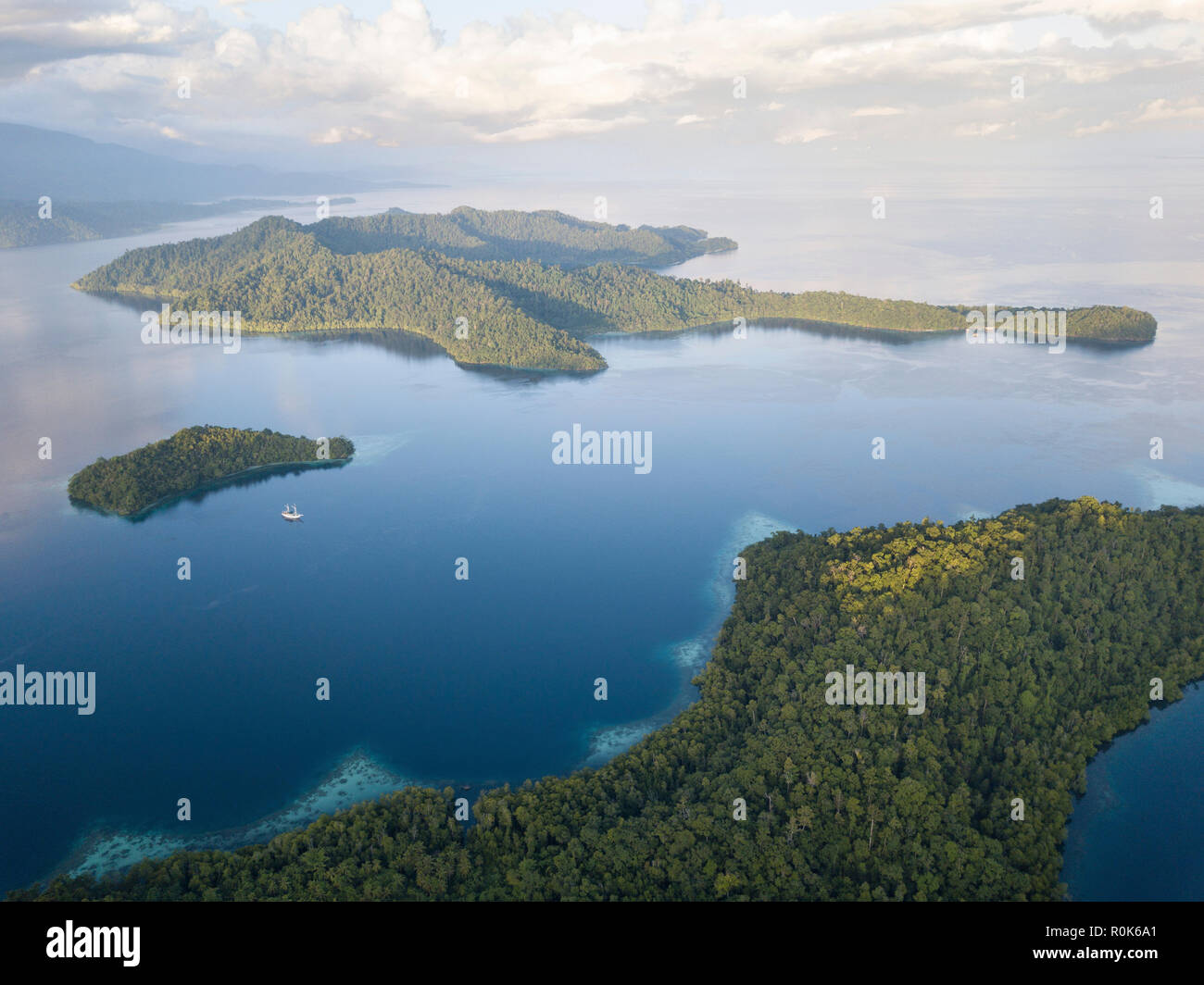 Un Pinisi goélette se trouve à l'ancre dans une région éloignée du Raja Ampat en Indonésie orientale. Banque D'Images Un Pinisi goélette se trouve à l'ancre dans une région éloignée du Raja Ampat en Indonésie orientale. Banque D'Images
