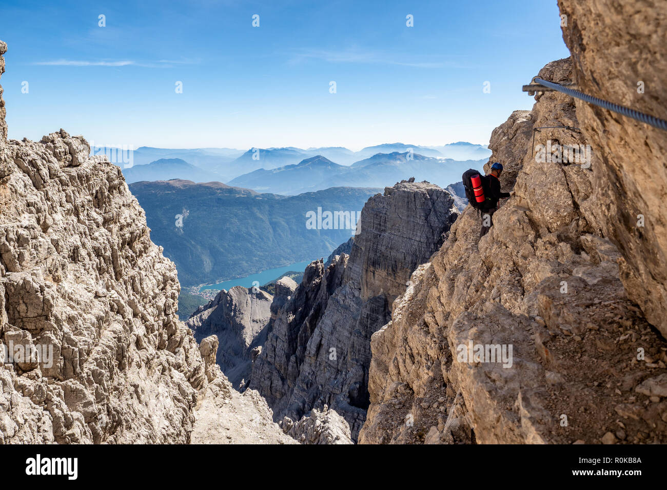 Homme d'alpiniste sur une via ferrata dans paysage à couper le souffle des Montagnes des Dolomites en Italie. Billet d'adventure concept. Banque D'Images