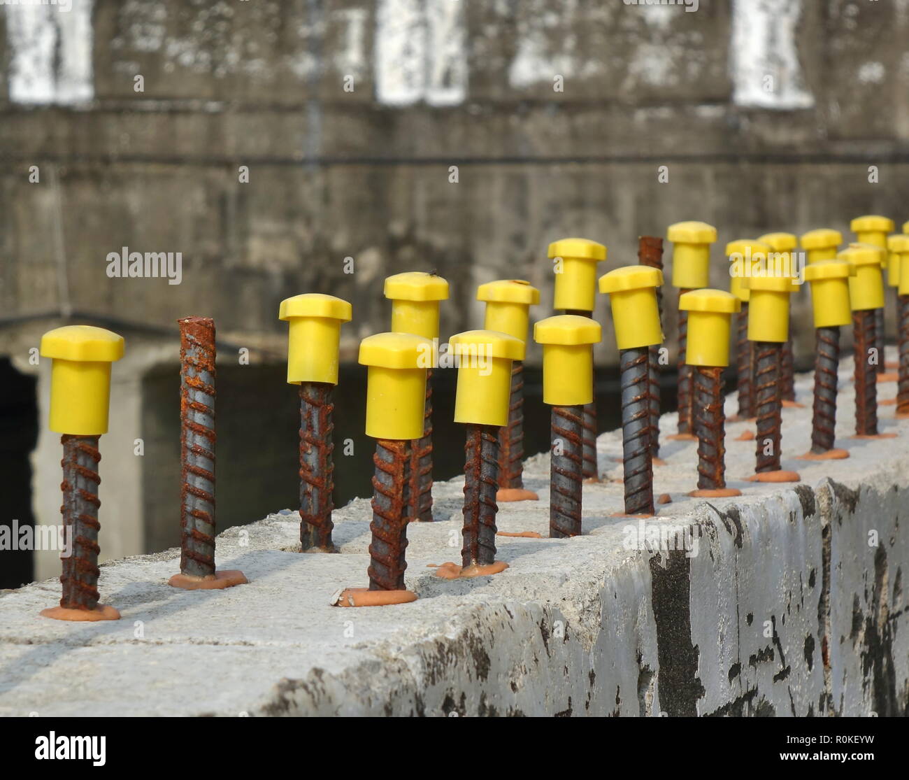 Les tiges d'armature en acier fin avec des chapeaux jaune Photo Stock -  Alamy