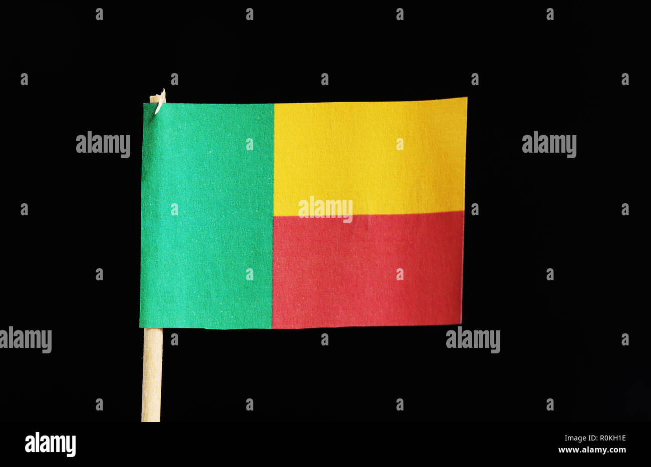 Original et un drapeau officiel du Bénin au cure-dent sur fond noir. Un bicolore horizontal de jaune et rouge avec une bande verticale verte à l'aide du palan Banque D'Images