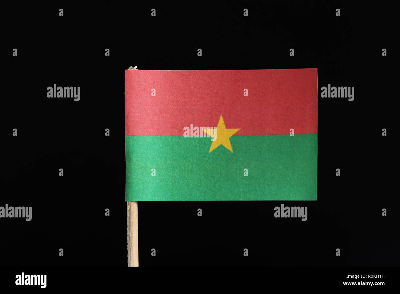 Un drapeau original et officiel du Burkina Faso au cure-dent sur fond noir. Se compose de deux bandes horizontales rouge et vert avec étoile jaune Banque D'Images