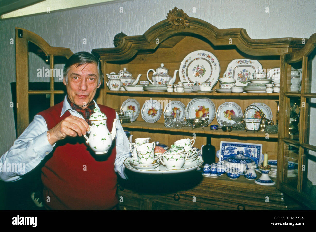 Peter René Körner, acteurs et actrices deutscher und vor seinem Sänger, dans Porzellanschranki Rösrath bei Köln, Deutschland 1984. L'acteur et chanteur allemand Peter René Koerner avec son placard plein de Chine à Roesrath, près de Cologne, Allemagne 1984. Banque D'Images