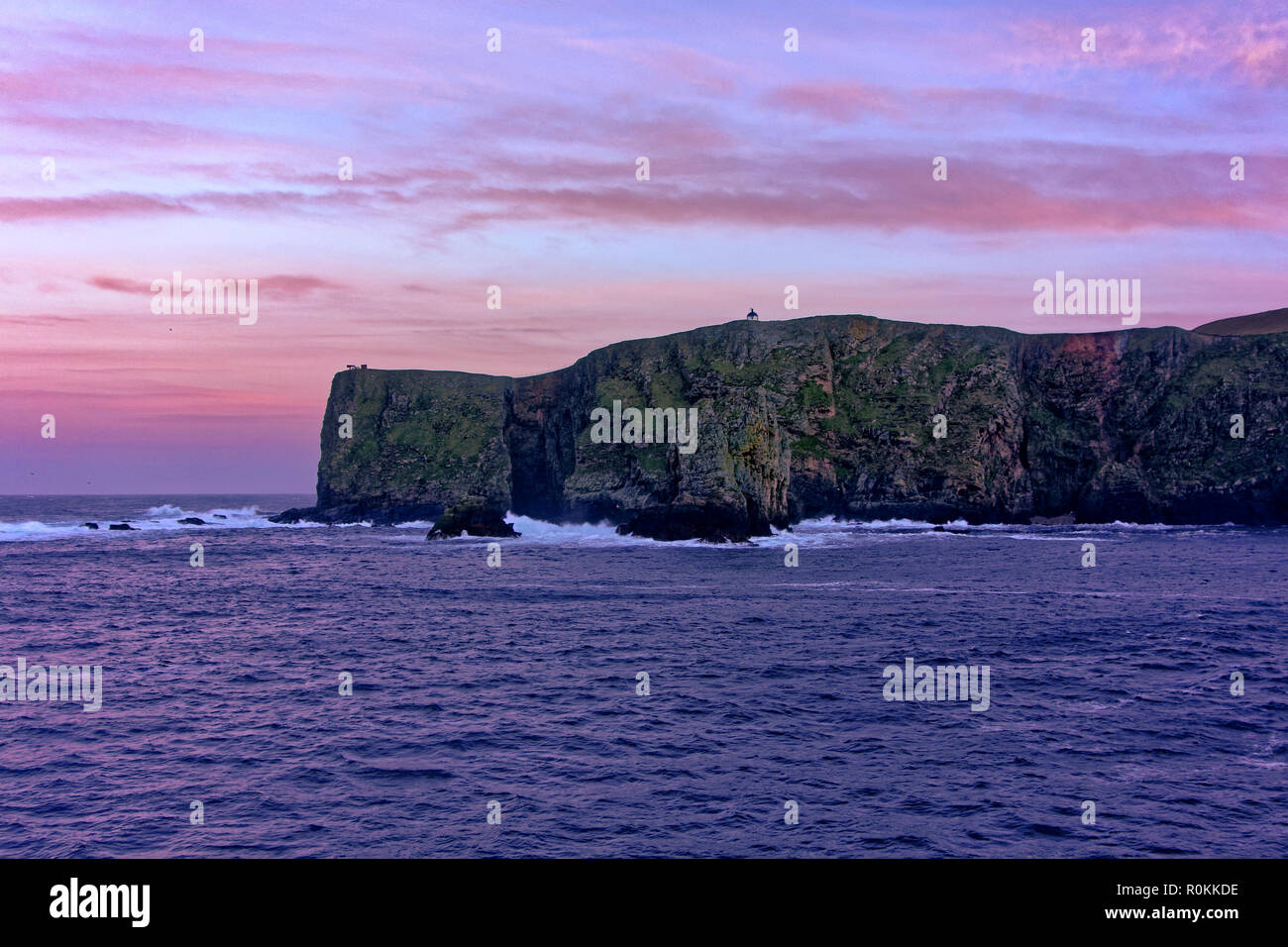 Falaises au côté nord de Fair Isle, l'Ecosse vu au crépuscule. Fair Isle est la plus lointaine des îles habitées au Royaume-Uni. Banque D'Images