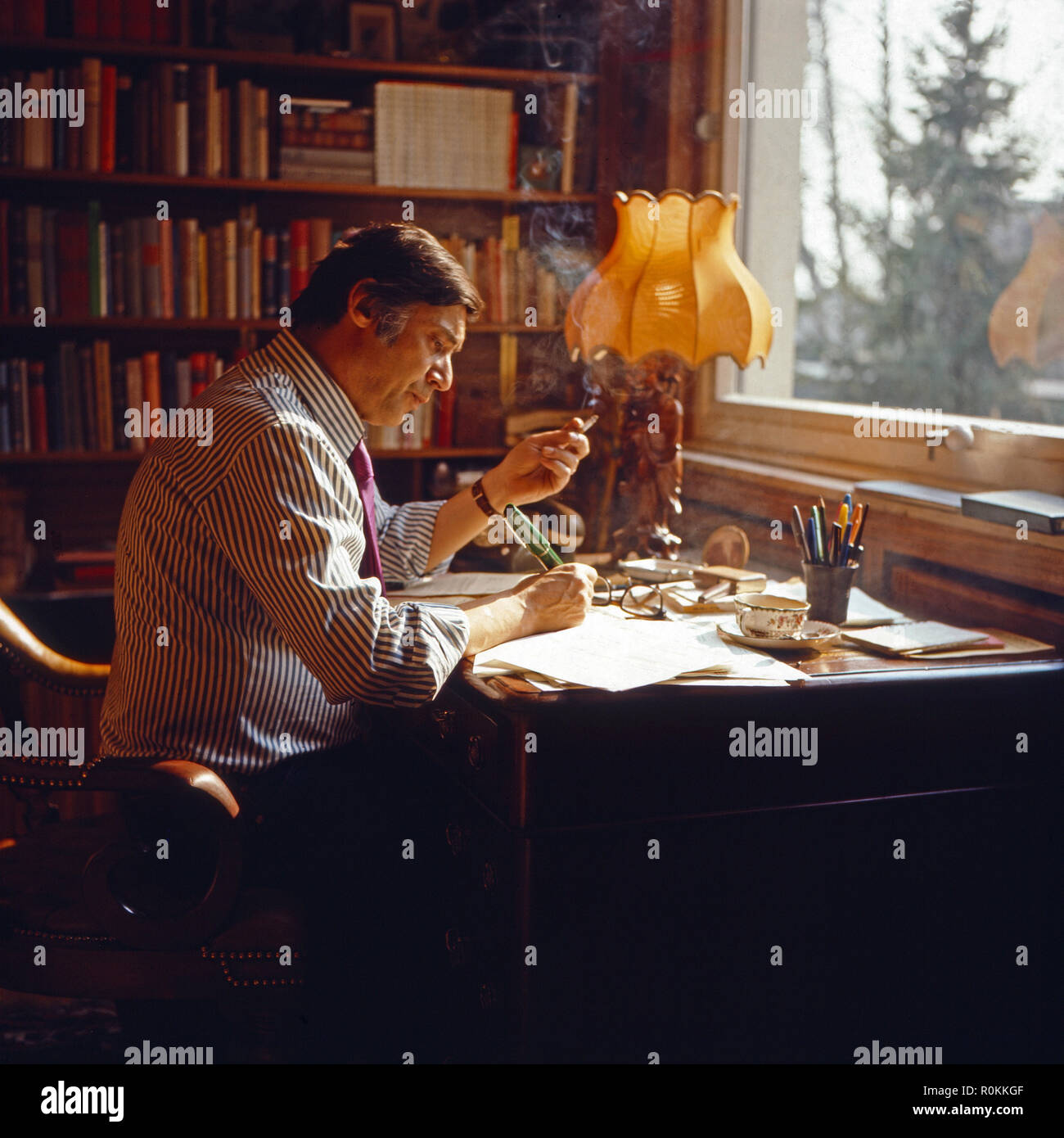 Peter René Körner, acteurs et actrices deutscher und Sänger, am Schreibtisch dans seinem Arbeitszimmer à Rösrath bei Köln, Deutschland 1971. Chanteur et acteur allemand Peter René Koerner à ce bureau dans son bureau à Roesrath, près de Cologne, Allemagne 1971. Banque D'Images