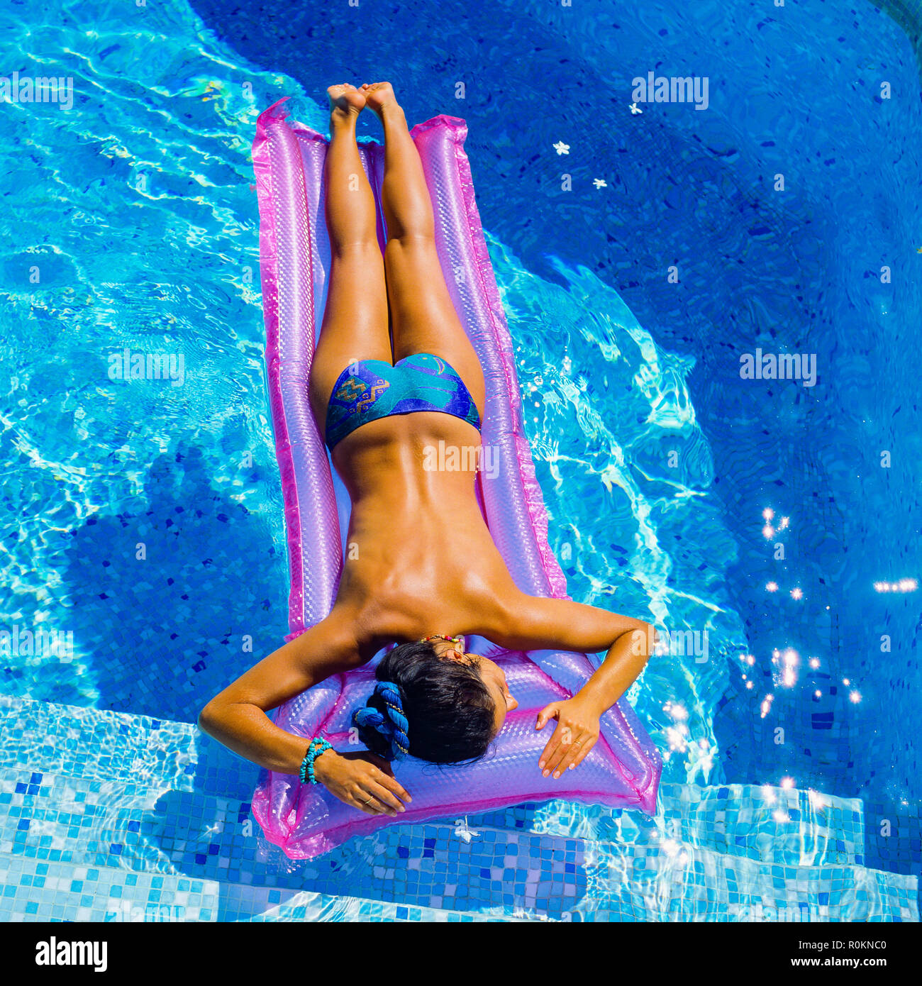 Vue d'en haut d'une jeune femme sans seins, bains de soleil sur un matelas à air rose, piscine, Guadeloupe, Antilles Françaises, Petites Antilles, Banque D'Images